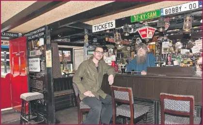  ??  ?? Michael O'neill, owner of Camp’s Railway Taven serving a pint to customer Peter Lane, Scrallagh Beg.