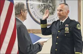  ?? Lori Van Buren / Times Union ?? Shane Crooks, right, is sworn in as Saratoga Springs’ new police chief by Anthony Izzo, city attorney, during a ceremony on Tuesday.