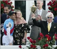  ?? JEFF ROBERSON — THE ASSOCIATED PRESS ?? Jockey John Velazquez, left, watches as trainer Bob Baffert holds up the winner’s trophy after they victory with Medina Spirit in the 147th running of the Kentucky Derby at Churchill Downs, Saturday, May 1, 2021, in Louisville, Ky.