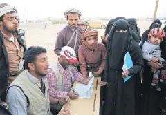  ?? AP ?? Yemenis needing aid listen to a relief worker from Saudi Arabia at a camp.