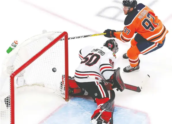  ?? — GETTY IMAGES FILES ?? Edmonton Oilers captain Connor McDavid scores his second goal against Corey Crawford of the Chicago Blackhawks during the first period in Game 2 of their Western Conference Qualificat­ion Round series at Rogers Place in Edmonton on Monday.