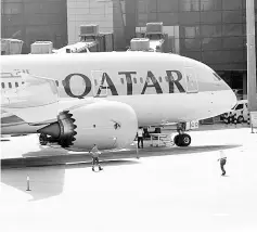  ??  ?? A Qatar Airways aircraft is seen at Hamad Internatio­nal Airport in Doha, Qatar. Qatar Airways will back Meridiana to be Italy’s top airline, supplying it with wide and narrow bodied jets to help expand its network, the Middle East carrier’s chief...