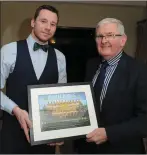  ??  ?? Boherbue player Jerry O’Connor receives a presentati­on from Joe Kearns,chairman, Duhallow Junior Board at the function in the Killarney Heights Hotel.