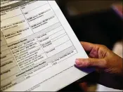  ?? AP 2017 ?? A woman looks over her health insurance benefit comparison chart which shows out-of-network coverages dropped. The Kaiser Family Foundation finds that more companies are making workers pay an annual deductible or increasing the amount they must spend before insurance starts covering most care.