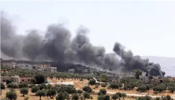  ?? — AFP photo ?? A picture shows smoke blowing from buildings on fire that were hit by reported Russian air strikes in the rebel-hold town of Muhambal, about 30 kilometres southwest of the city of Idlib.