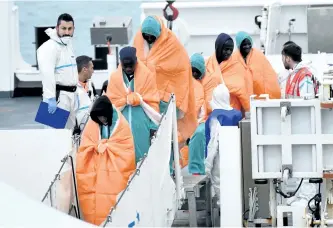  ?? GIOVANNI ISOLINO/GETTY IMAGES ?? Migrants disembark from the Italian Coast Guard vessel Diciotti on Monday in Catania, Italy, following a rescue operation at sea. At least 64 people are feared to have drowned in a shipwreck off Libya after a dinghy, possibly carrying some 150...