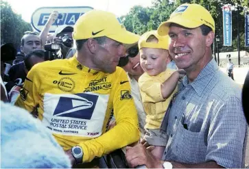  ??  ?? Ochowicz holds Lance Armstrong’s son Luke at the end of the 2001 Tour de France