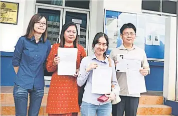  ??  ?? STANDING UP FOR DEMOCRACY: State PKR Women exco member Jamilah (second right) with Simon (right), Patricia (second left) and another PKR Women member showing reporters the police report they lodged at the Simpang Tiga Police Station.