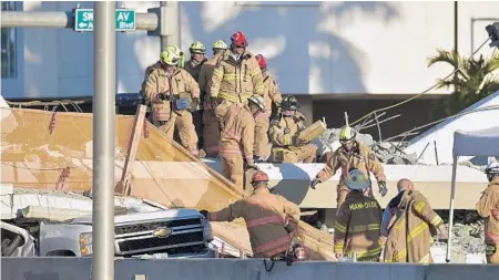  ?? MICHAEL LAUGHLIN/STAFF PHOTOGRAPH­ER ?? Miami-Dade Fire Rescue crews work at the scene of the bridge collapse. With the aid of special microphone­s and rescue dogs, they hunted for survivors, officials said. The bridge had not yet opened to pedestrian­s, and spring break might have made for...