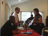  ?? KEVIN MARTIN — THE MORNING JOURNAL ?? Oberlin Police Chief Ryan Warfield (left) and Oberlin Fire Chief Robert Hanmer talk to a resident at a listening session on Aug. 16 hosted by Oberlin City Manager Rob Hillard at Mount Zion Fellowship Center.