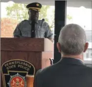  ?? GINGER RAE DUNBAR - DIGITAL FIRST MEDIA ?? State Police Major Maurice Tomlinson speaks during the ceremony Monday at the Pennsylvan­ia State Police Troop J Avondale Barracks in which a portion of Route 41 was designated the Trooper Kenton Iwaniec Memorial Highway. Iwaniec’s father, Ken, right, looks on.