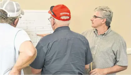  ?? DANIEL BROWN/THE GUARDIAN. ?? Neil Lawless, right, explains some of his bridge designs to fishermen in North Lake. The bridge constructi­on will be starting on Aug. 12.