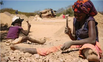  ??  ?? A woman and child break rocks at a copper quarry and cobalt pit in Lubumbashi, DRC. Photograph: Junior Kannah/Getty