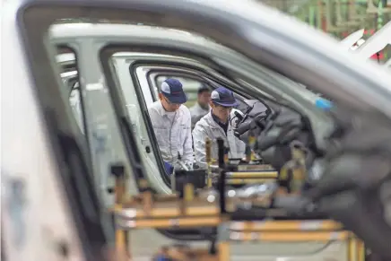  ?? CHINATOPIX VIA AP ?? Workers assemble vehicles at the Dongfeng Honda plant in Wuhan, China. China’s auto sales shrank by 5.3 percent in July from a year earlier as SUV demand declined.