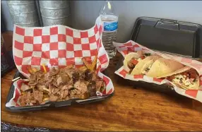  ??  ?? Anyone hungry? This is just a small sample of the menu items at Outlaw Smoke BBQ in Fraser, The owners are holding a toy drive.