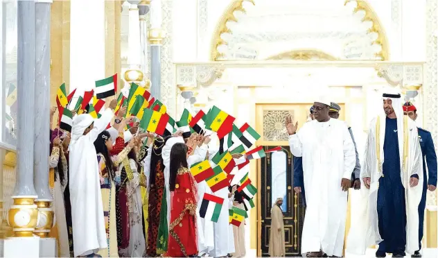  ?? WAM ?? ↑
Sheikh Mohamed Bin Zayed Al Nahyan and Macky Sall greet schoolchil­dren during an official visit reception at Qasr Al Watan on Thursday.