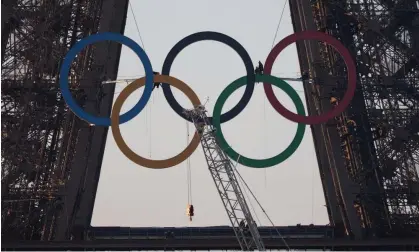  ?? Photograph: Lafargue Raphael/ABACA/Rex/Shuttersto­ck ?? Workers hang the Olympic rings symbol on the Eiffel Tower. Events on track and field are set to be eclipsed by political turmoil.