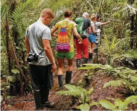  ?? Doug Hansen / TNS ?? Rubber boots were a necessity on a day hike through the jungle.