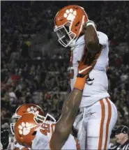  ?? TIMOTHY D. EASLEY — THE ASSOCIATED PRESS ?? Clemson’s linebacker Jarvis Magwood ( 46) holds up Kelly Bryant ( 2) following his touchdown during the second half of their NCAA college football game against Louisville, Saturday in Louisville, Ky. Clemson won 47- 21.