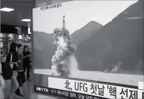  ??  ?? People pass by a TV news broadcast showing file footage of North Korea’s ballistic missile that the North claimed to have launched from a submarine, at Seoul Station in Seoul, South Korea, Wednesday. North Korea on Wednesday launched the missile in an...
