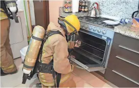  ??  ?? A firefighte­r in Tulum, Mexico, examines the condo where an Iowa family died. A water heater was the source of the gas leak.