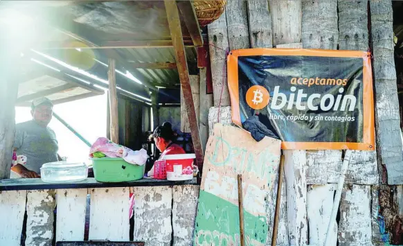  ?? REUTERS ?? Un cartel en el que se puede leer «se aceptan Bitcoin: libre, rápido y sin contagios» cuelga de un establecim­iento en Punta Roca Beach