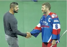  ?? CLIFFORD SKARSTEDT/EXAMINER ?? Peterborou­gh profession­al wrestler Bobby Roode is greeted by Lakers captain Scott Self before dropping the ball before THE Peterborou­gh Century 21 Lakers and Six Nations Chiefs Major Series Lacrosse Final Game 5 on Tuesday NIGHT at the Memorial Centre....