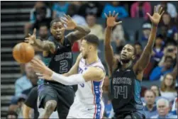  ?? NELL REDMOND — THE ASSOCIATED PRESS ?? 76ers guard Ben Simmons, center, passes around a double team by Hornets forwards Marvin Williams (2) and Michael Kidd-Gilchrist (14) in the first half Sunday in Charlotte, N.C.