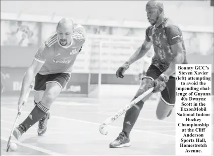  ?? ?? Bounty GCC’s Steven Xavier (left) attempting to avoid the impending challenge of Guyana 40s Dwayne Scott in the ExxonMobil National Indoor Hockey Championsh­ip at the Cliff Anderson Sports Hall, Homestretc­h Avenue.