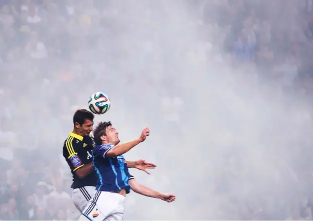  ??  ?? Above: This shot is from the Swedish premier league with clouds of smoke wafting from the stands from spectators’ smoke grenades, which helped make the image visually interestin­g.