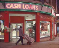  ?? — Reuters ?? A man walks past a cash loan store in Palm Springs, California.