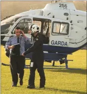  ??  ?? Sgt Stephen Ennis and a crew member disembark from a Garda helicopter at Gorey Showground­s in ongoing operations in North Wexford.