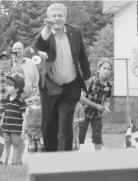  ?? CLEMENT ALLARD/ THE CANADIAN PRESS ?? Prime Minister Stephen Harper throws a bean bag while playing a game during a gathering for the St-Jean-Baptiste Day holiday in St-Lazare-de-Bellechass­e on Tuesday.