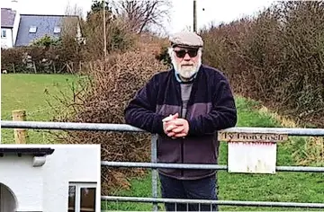  ?? ?? Above, Gerald Wilson, pictured in his driveway, feels marooned at his property in Brynsiency­n, left, as he has no legal highway access to it due to a legal wrangle over the status of Lon Chwarelau, below