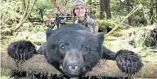  ??  ?? TO DIE FOR: Bachman poses with the body of a bear brought down in a crossbow hunt