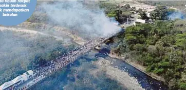  ??  ?? PANDANGAN dari udara orang ramai yang bertempur dengan tentera Venezuela di atas jambatan Francisco de Paula Santander menghubung­kan Cucuta di Colombia dengan Urena di Venezuela. - AFP