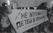  ??  ?? At a rally Wednesday in St. Petersburg against a ban on U.S. adoption of Russian children, a protester’s poster says ‘Do not involve children in politics.’