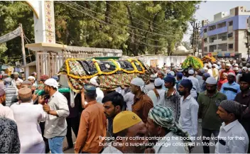  ?? People carry coffins containing the bodies of the victims for their burial after a suspension bridge collapsed in Morbi. ??