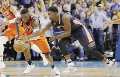  ??  ?? OKLAHOMA: Oklahoma City Thunder guard Victor Oladipo, left, and New Orleans Pelicans guard Jrue Holiday (11) go after a loose ball during the second half of an NBA basketball game in Oklahoma City, Sunday. Oklahoma City won 101-92. —AP