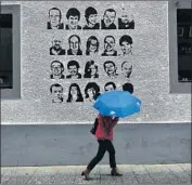  ?? Alvaro Barrientos Associated Press ?? PORTRAITS of people held by ETA appear on a wall in the Basque town of Hernani in northern Spain.