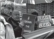  ?? ALASTAIR GRANT/AP ?? Pro-Brexit protesters hold out their placards and flags Monday in front of the Houses of Parliament in London.