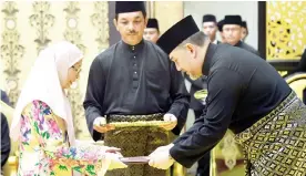  ??  ?? Yang di-Pertuan Agong Sultan Muhammad V presents the instrument of appointmen­t to Datuk Seri Dr Wan Azizah as Deputy Prime Minister as well as Minister of Women and Family Developmen­t at the swearing-in ceremony of Cabinet ministers at Istana Negara...