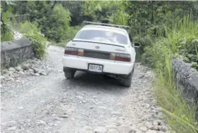  ??  ?? A motor vehicle goes over the bridge officially closed by the National Works Agency but reopened by residents of Pedro, Clarendon.