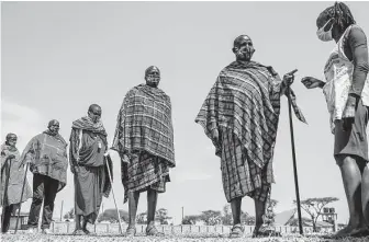  ?? Brian Inganga / Associated Press ?? Maasai men line up Saturday to receive the AstraZenec­a vaccine at a clinic in Kimana, southern Kenya. Wealthier nations are awash in vaccines, while they are scarce in poorer countries.