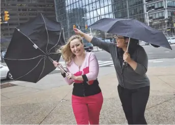  ?? PHOTOS BY ROMAIN BLANQUART, DETROIT FREE PRESS ?? Amanda Berry, left, and Gina DeJesus walk through the rain in Cleveland on April 20. The two say they had to relive their abuse while writing the memoir.