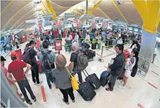  ?? EFE ?? Decenas de personas hacen cola en el aeropuerto de Madrid-Barajas la pasada semana.