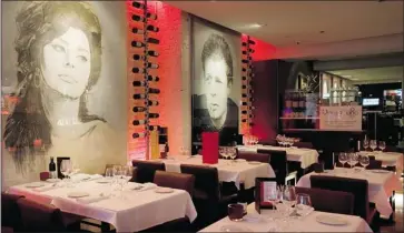  ?? GRAHAM HUGHES THE GAZETTE ?? The Dolce Vita-inspired decor features blown-up portraits of cinema luminaries like Marcello Mastroiann­i and Sophia Loren. It’s all glittery in pomodoro and pink, moody backlighti­ng and a red Vespa mounted behind the bar.