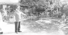  ??  ?? Bosi pointing at the stagnant water at Winny’s house.