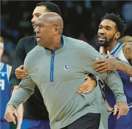  ?? AP ?? Kings coach Mike Brown has to be restrained as he argues call in second half against Bucks on Sunday.