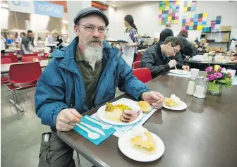  ??  ?? Mike Gosling prepares to tuck into his Easter dinner at the Union Gospel Mission in Vancouver on Saturday. — JASON PAYNE PNG